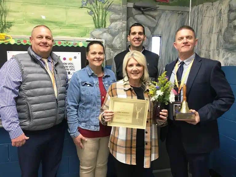 Lori Hendrix, the school level Teacher of the Year at DeKalb Middle School, was visited in her classroom Tuesday morning by Principal Caleb Shehane,, Director of Schools Patrick Cripps, Supervisor of Instruction Randy Jennings, and Assistant DeKalb Middle School Principal Teresa Jones who presented her with a school bell award, a floral arrangement, and a certificate granting her a day off from school with pay.