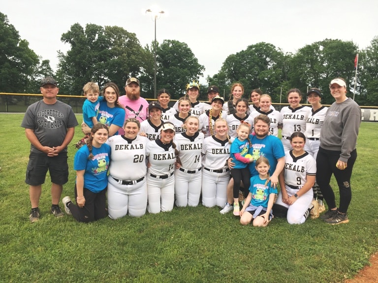 Athletes and coaches of the DCHS Tigerette Softball Program paused for a photo Monday evening with the Brandon Cox family in support of their daughter, 5 year old Carrigan who was recently diagnosed with leukemia. Carrigan threw out the first pitch of the Tigerette’s Region Tournament game in Smithville against Marshall County