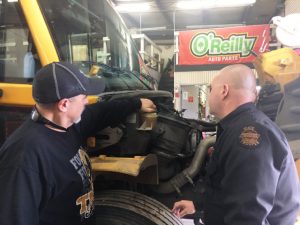 School Transportation Supervisor Jimmy Sprague and THP Trooper/Bus Inspector Craig Wilkerson checking under the hood of bus at school bus garage