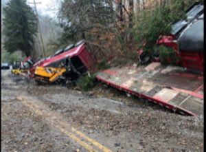 2011 Volvo dump truck pulling a flatbed trailer overturns on Holmes Creek Road