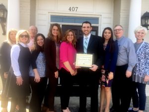 Local Attorney Jeremy Trapp and wife receive Chamber's Community Improvement Award. They are joined by staff, guests, and friends for the special occasion.