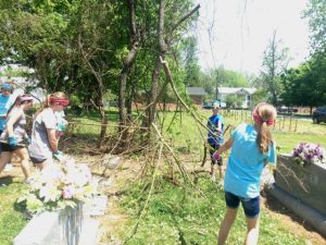 Girl Scouts and Volunteers cutting and removing tree limbs from Town Cemetery Saturday