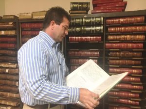 County Clerk James L. (Jimmy) Poss looking through bound book of marriage records
