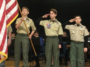 Members of Boy Scout Troop 347 salute the flag during the National Anthem