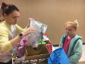 Child gets help preparing blessing bag during regifting event