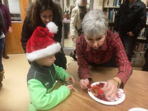 Christmas on the Square: Kathy Hendrixson helps children make a Christmas ornament at Justin Potter Library