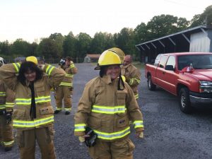 2018 DeKalb Fire Department Citizens’ Fire Academy participants dressed in firefighter turnout gear: Foreground- Sandra Caffee and Rachel Phipps. Background- Angela Johnson and Jimmy Sprague