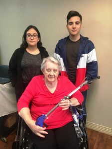 NHC resident Bobbie Ervin receives a pickup tool made by DCHS students Julianna Juarez and Alberto Lucio through the STEM Technology and CTE programs in partnership with NHC Health Care Center of Smithville