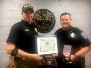 Smithville Police Chief Mark Collins presents Commendation Certificate and medal badge to Officer Brandon Donnell