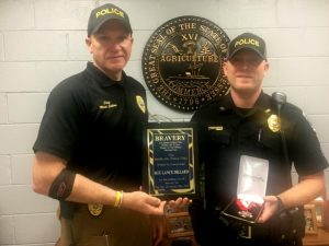 Smithville Police Chief Mark Collins presents plaque for bravery and medal badge to Sergeant Lance Dillard