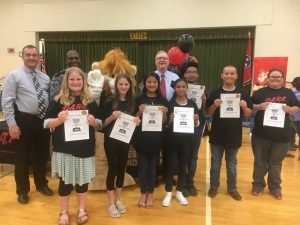 5th Grade DARE Graduation Essay Winners at Northside Elementary School: left to right front row- Sarah Pugh, Elisabeth Sturdivant, Rosio Godinez, Genesis Roblero, Jerett Hamilton, Brownie Johnson, and Overall Winner Olivia Hale. Back Row- Sheriff Patrick Ray, DARE Officer Lewis Carrick, DARE Mascot DAREN the Lion, and General Sessions/Juvenile Court Judge Bratten Cook, II.