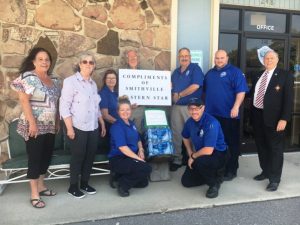 (PICTURED: #5 Smithville Chapter #374 leaders of the Order of the Eastern Star showed their appreciation to the DeKalb EMS/Ambulance Service Wednesday by donating three cases of bottled water. Pictured: Eastern Star Organist Gay Vanatta, Eastern Star Worthy Matron Pat Wilt, EMS-AEMT Misty Green, EMS- EMT-B Michelle Haggard (kneeling), Worthy Patron Dr. Jerry Paul Vanatta, EMS Director Hoyte Hale, EMS- EMT PCC Kenny Moffitt (kneeling), EMS-EMT-P Tim Briggs, and Eastern Star Chaplain Dr. Robert R. Atnip)