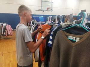 Student checking out selection of shirts at the DMS Saint Bernard Boulevard Clothing Market