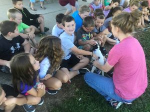 DeKalb Animal Shelter Volunteer Laura Parsley shows off puppy to DeKalb West School 2nd graders