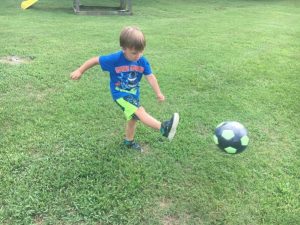 Nolan Martin having fun kicking ball at Alexandria playground Friday