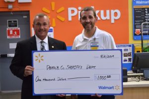 Sheriff Patrick Ray receives $1,000 donation for the Sheriff's Citizens Academy from Steve Abell, Smithville Walmart Store Manager
