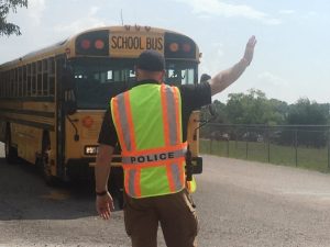Smithville Police Chief Mark Collins strops traffic on East Bryant Street as school bus enters the road from the entrance of Smithville Elementary School