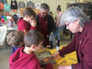 Jeffrey and Katie Dheere of OMG Leatherworks at Alexandria showing kids how to make leather products at Paislee’s Foundation Craft & Home Show Saturday
