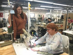 Amanda Callis, Plant Manager of 620 Pelham, Inc (formerly Omega Apparel) with employee Estelle Sanchez who is shown sewing military waterproof Goretex seam sealed Parka trousers for the US Navy