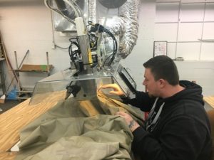 Employee Anthony Skinner of 620 Pelham, Inc (formerly Omega Apparel) shown seam sealing for the Goretex waterproof parka