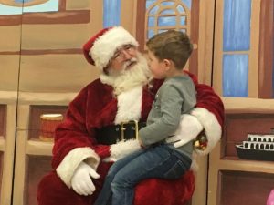 Santa visits with youngster on the North Pole Stage during Festival of Trees 2nd Annual Opening Night,