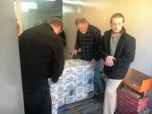 Smithville Food Lion employees Mitchell Herrin (back to camera) and Christian Owen (right) help God’s Food Pantry volunteer Stevie Cripps (center) stack “Food Lion Holidays without Hunger” food boxes onto a pallet Wednesday.