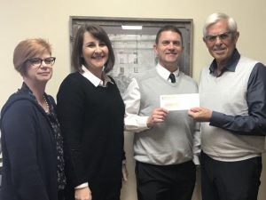 Dr. Dan Tollett, Utrust Administrator, presents a check for $15,400 to DeKalb County Superintendent Patrick Cripps. Supervisor of Instruction Michelle Burklow and Federal Projects Supervisor Danielle Collins and look on.