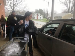 Ellie Cripps loading food bags into waiting vehicle during drive thru food distribution for students.The “Meals for Kids” drive through distribution will continue this week at DeKalb Middle School, DCHS, and at DeKalb West School. The food pick-up, hosted by the DeKalb County School System with support of local churches will resume Monday and Thursday, April 6 and 9 from 10:30 a.m. until noon at DeKalb Middle School, DCHS, and at DeKalb West School.