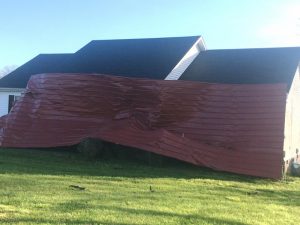 High winds from a powerful storm early Sunday morning March 29 caused some structure damage and power outages for several hours in DeKalb County. Picture here shows a portion of metal roof blown off Mystick Market on Highway 56 South which came to rest against a home across the highway.