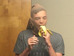 DCHS student Braedon Jett eats banana through stocking over his head in response to donation pledge to WJLE Project Graduation Radiothon last year