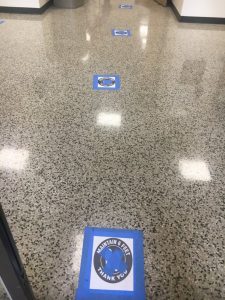 Floor signs at Early Voting Courthouse entrance mark where voters should stand to ensure they are still maintaining the appropriate distance while waiting their turn in line