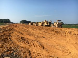 Photo shows Jones Brothers Contractors building a new section of Highway 56 south across South Tittsworth Road bypassing the existing portion of Highway 56 at this location. WJLE Radio Station and DeKalb Memorial Gardens are barely visible to the right in the photo