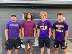 Coach Steve Trapp and Tiger football players Axel Aldino, Isaac Knowles, and Desmond Nokes.