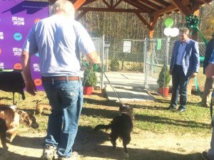 Randy Boyd of the Boyd Foundation (right) looks on as pet owners bring their dogs into the new Smithville Dog Park for the first time Friday following the ribbon cutting and grand opening.
