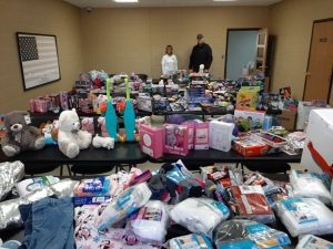 Photo shows Smithville Police Chief Mark Collins and Records Clerk Beth Adcock with a portion of the gifts donated for families in addition to Smithville Head Start children. Cash Express set out donation boxes and money jars at businesses for this collection effort..