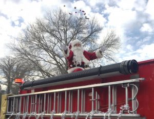 Santa arrives by fire engine in Liberty during Sunday's Christmas Parade there tossing candy to the crowd
