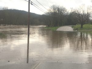 Smith Fork Creek overflows is banks across West Main Street in Liberty Sunday