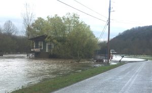 Dry Creek overflows its banks and surrounds a home on East Main Street Dowelltown Sunday