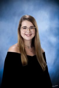 A moment of silence was observed at Friday night’s commencement in honor of the late DCHS Class of 2021 senior Cassie Maxwell who died in a car crash last month and during the program there was one vacant chair with only a framed photo of Cassie in the place where she would have sat among her classmates on the football field. Later in the program, black and gold balloons were released when her name was called during the awarding of diplomas