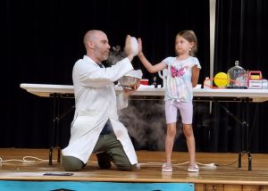 Hazmatt Bond performs science experiment on the states of matter with youngster at Thursday's Summer Reading Opening Day Party