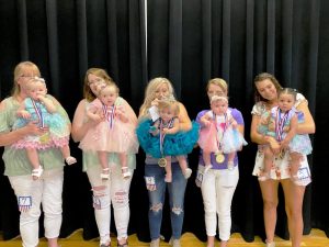 Miss Jamboree Pageant: girls 7-12 months group: Queen Briley Ann Cripps (center), 9 month old daughter of Corey and Kami Cripps of Smithville. 1st runner-up and Most Photogenic: Eliza Jane Kemp (2nd from left), 11 month old daughter of Hunter and Reba Kemp of Liberty. 2nd runner-up: Journee Nikole Garnett Davenport (2nd from right) , 7 month old daughter of Darian and Travis Davenport of Smithville. 3rd runner-up: Remington Mae Kemp (far left), 11 month old daughter of Hunter and Reba Kemp of Liberty. 4th runner-up and Prettiest Hair and Eyes: Dayvani Haggard (far right), 12 month old daughter of Caleb Haggard and Haley Haggard of Smithville. Receiving an award for Prettiest Attire was Emma Rose Chapman, 9 month old daughter of Jocelyn Williams and Corey Chapman of Smithville.