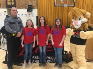 Pictured left to right: DeKalb West School SRO and D.A.R.E. Fifth Grade Instructor Billy Tiner of the DeKalb County Sheriff’s Department with D.A.R.E. Essay Winners Makenna Lomas, Kaylee Womack, and Overall Essay Winner Halia McDaniel with the D.A.R.E mascot Daren the Lion at the DWS D.A.R.E graduation Wednesday.