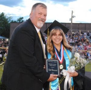 Principal Bruce Curtis presents Faith Betancourt with White Rose Award at DCHS graduation in May