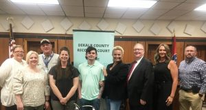 Dylan Goodman (pictured in the center) had plenty to celebrate on the occasion of his graduation from the DeKalb County Recovery Court program Wednesday afternoon. The observance was held in the circuit courtroom of the courthouse hosted by members of the DeKalb Recovery Court team. It also happened to coincide with National Drug Court Month. Pictured left to right: Allison West, Assistant District Public Defender; Abigail Wood of the DeKalb Sheriff’s Department; Larry Latzman, Certified Peer Group representative; Jammie Hood, Family Treatment Case Manager; Dylan Goodman, Rhonda Tiefenauer, Recovery Court Case Manager; DeKalb General Sessions and Juvenile Court Judge Bratten Cook, II; Kate Arnold, Recovery Court Coordinator; and Detective James Cornelius of the Smithville Police Department