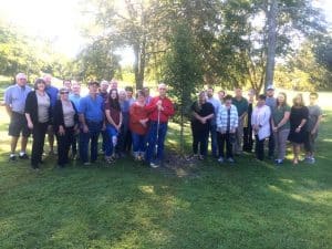 The DeKalb County Soil Conservation District paid tribute to the late Anita Houk Wednesday morning by planting a Sunset Maple tree in her memory at Green Brook Park. Pictured left to right are co-workers, family, and friends: Genrose Davis, Judy Sandlin, Tommy Melton, Taylor Patterson, Mary Melton, Bernard Houk, Jennifer Winchester, Delilah Barrett, Donnell Poss, Melissa Oliver, Tara Hale, and Judy Alsup. Back row: Jimmy Womack, Jimmy Herndon, Zach Fuson, Gene Robinson, Danny Curtis, Donny Green, Deborah Agee, Linda Robinson, Shawn Rice, Jason Winchester, Andria Graham, Sonny Barrett, Pamela Hale, and Justin Winchester.