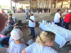 Mary Sanders showing kids how to make butter during Farm Day