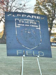 The unveiling of a sign (yet to be finished) to be displayed at the entrance of the DCHS Tiger and Lady Tiger Soccer Field designating it the “Dylan Kleparek Coach K Soccer Field”