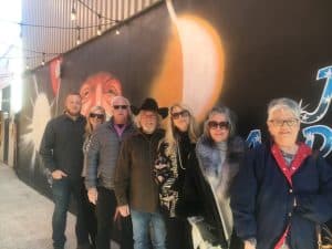 John Anderson with members of his family in John Anderson Alley standing in front of the mural which bears his likeness.