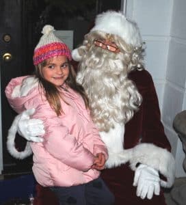 After arriving in town by sleigh in the Smithville Christmas Parade Saturday, Santa visits with children downtown