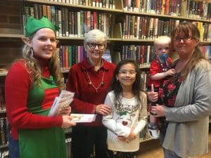 Children receive take home craft from Justin Potter Library during Christmas on the Square